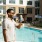 A man with a drink by a pool